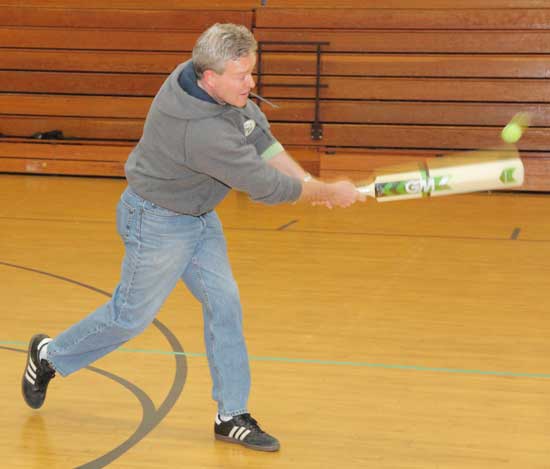 Peter Wharton connects with the ball in a game of cricket.