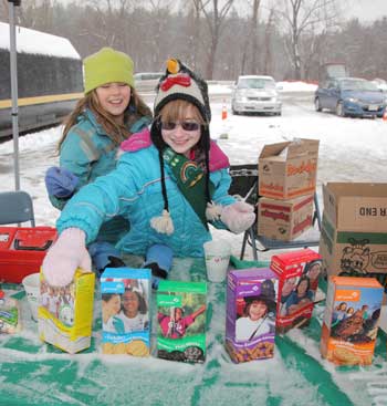 Undaunted by the snow, fourth-graders Ainsley Jones (left) and Bri Schmoyer sell Girl Scout cookies at the transfer station, Saturday, Jan. 21. (Photo by Lisa Aciukewicz)