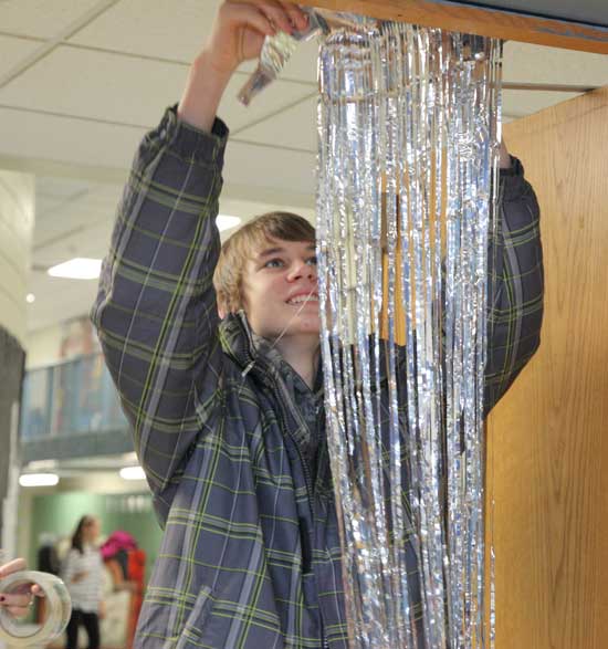 Ben Senkowski hangs metalic door curtains in the entranceway.