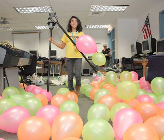 Arpitha Hayes wades across a floor covered with balloons while setting up for the Snow Ball, Saturday, Jan. 21.