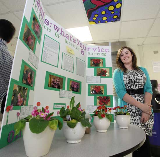 Senior Meghan Rooney displays her project, "The Effects of Nicotine and Caffeine on Primrose."