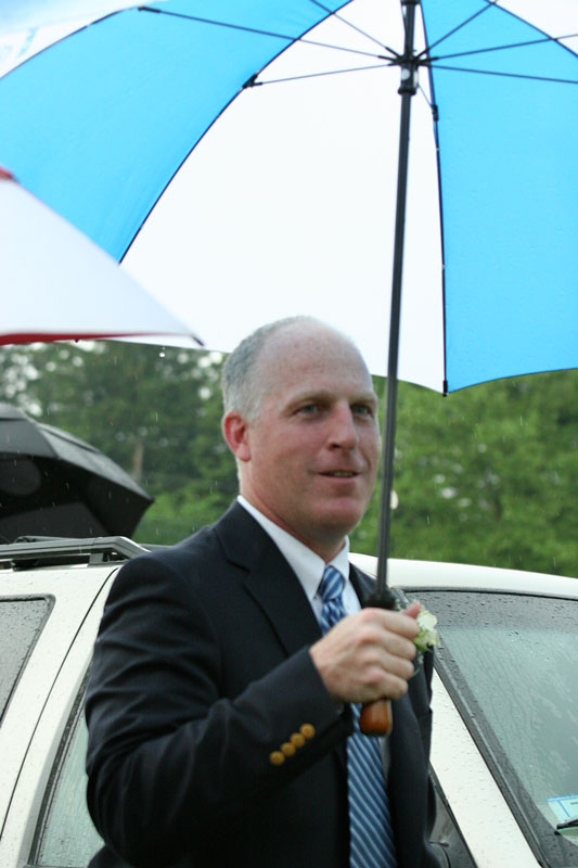 Principal Jim O'Shea arrives prepared for the weather. 