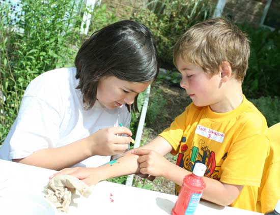 Ann Donaldson paints a cartoon animal on brother Jack’s arm.