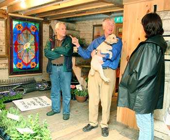 Dave Caponera listens as Jared Wollaston (holding his dog, Peppi) tells him and Mamie Wytrwal about the previous owners of his Elm Street home. (Photo by Lisa Aciukewicz)