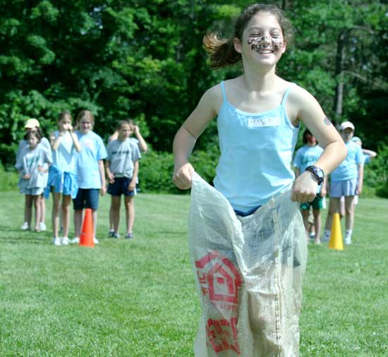 Lexi Dutkewych, with face paint declaring “lacrosse rules,” hops toward the finish line during field day at the elementary school.