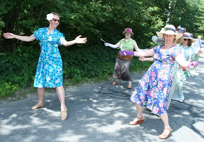 Garden Club members Alice Gerbura, Rachel Ogelsby, and Mary Vesenka Turner do a warmup shimmy before the parade.