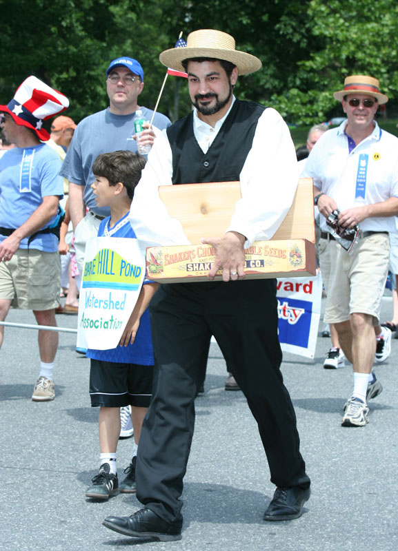 Dressed in Shaker garb, Jonathan Feist of the Historical Commission hands out candy in the parade. 