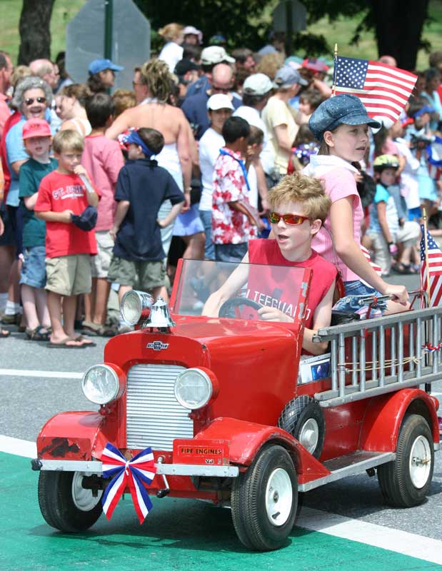 Joseph and Anelise Thibault motor down Mass. Avenue in their mini fire engine.