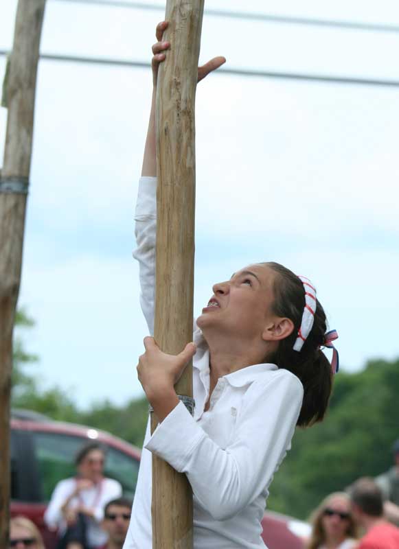 Caroline Mazzola gives it all she's got in the greased poll contest.