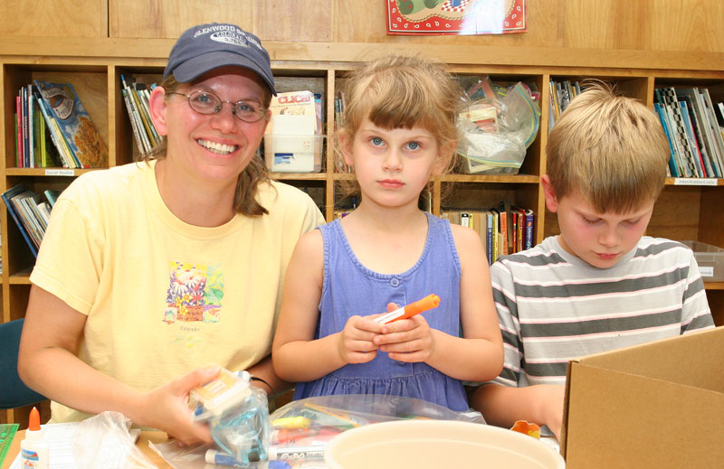 Andrea, April, and Christopher Steffek-Vogel label school supplies during the open house at the elementary school.