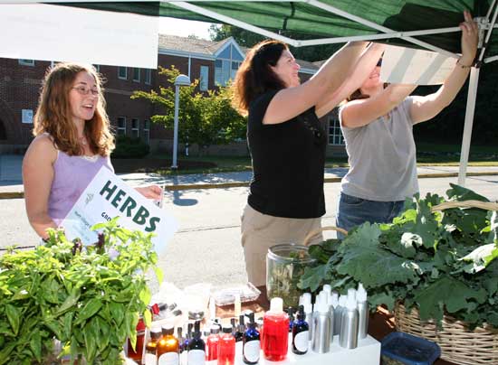 Sarah Tracey, LInda Russell, and Faith Venier set up their booth. 
