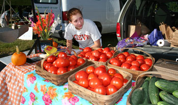Kristina Kronauer creates produce signs during the opening day of the Farmers’ Market. (Photo by Lisa Aciukewicz)