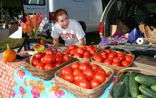 Kristina Kronauer creates produce signs for tomatos and cucumbers.