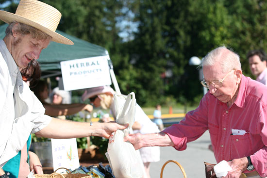 Tom Aciukewicz sells a bag of purple viking potatoes to Jeff Harris.