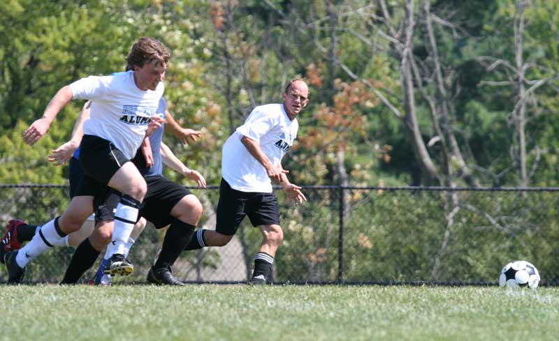 Alums David Gutzler and Don Phillips race for the ball.