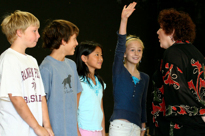 Dan Hillier, James Allen, Kiera Jean Frost, and Helena Wright volunteer to act out a story with Leeny Del Seamonds.