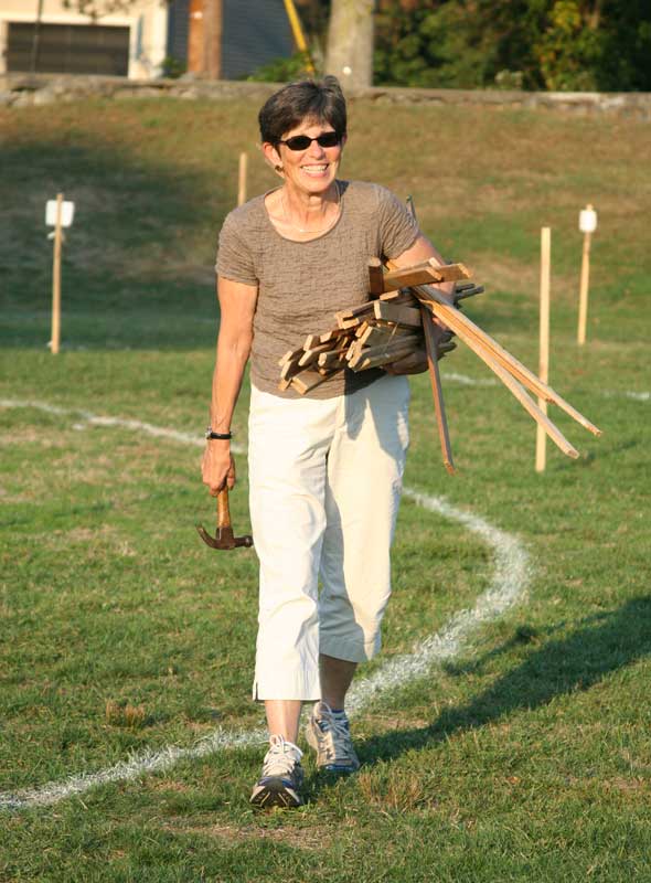 Pam Durrant carries a stack of poles to mark off booths.