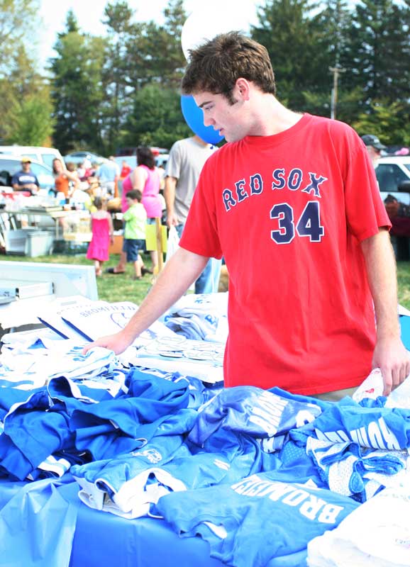 Home from college for the holiday weekend, Bryan Molinaro picks through the old Bromfield uniforms on sale to raise funds for Bromfield athletics.