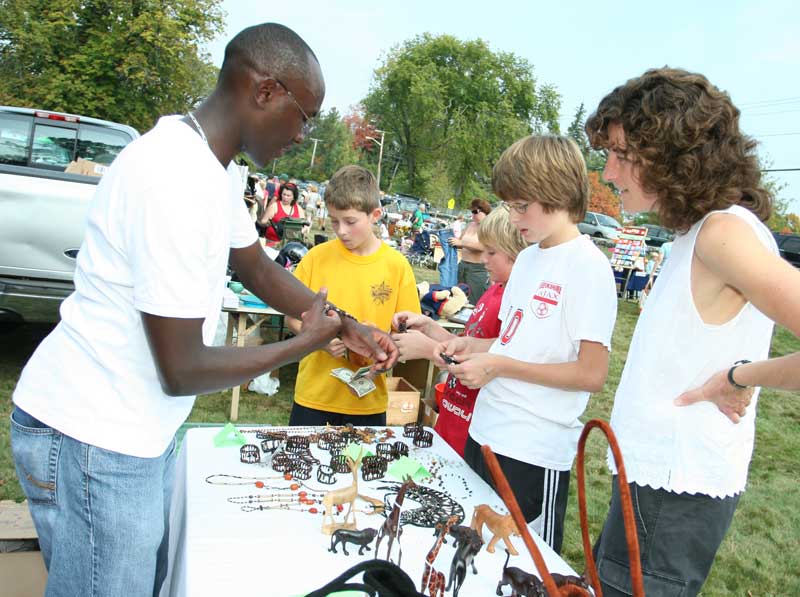 Joseph Keeva shows Will Malloy, Nate Pappas, Paul Malloy, and Robin Malloy jewelry from Kenya. The jewelry is made from porcupine quills collected from porcupine dens after the animals have left to forage.