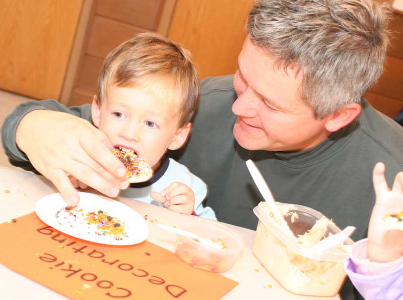 Liam Morrison enjoys a cookie after decorating it with the help of his dad, Bart.