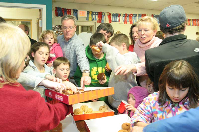 Free doughnuts almost ignite a fire of their own as plenty of raffle goers descend on a fresh box.