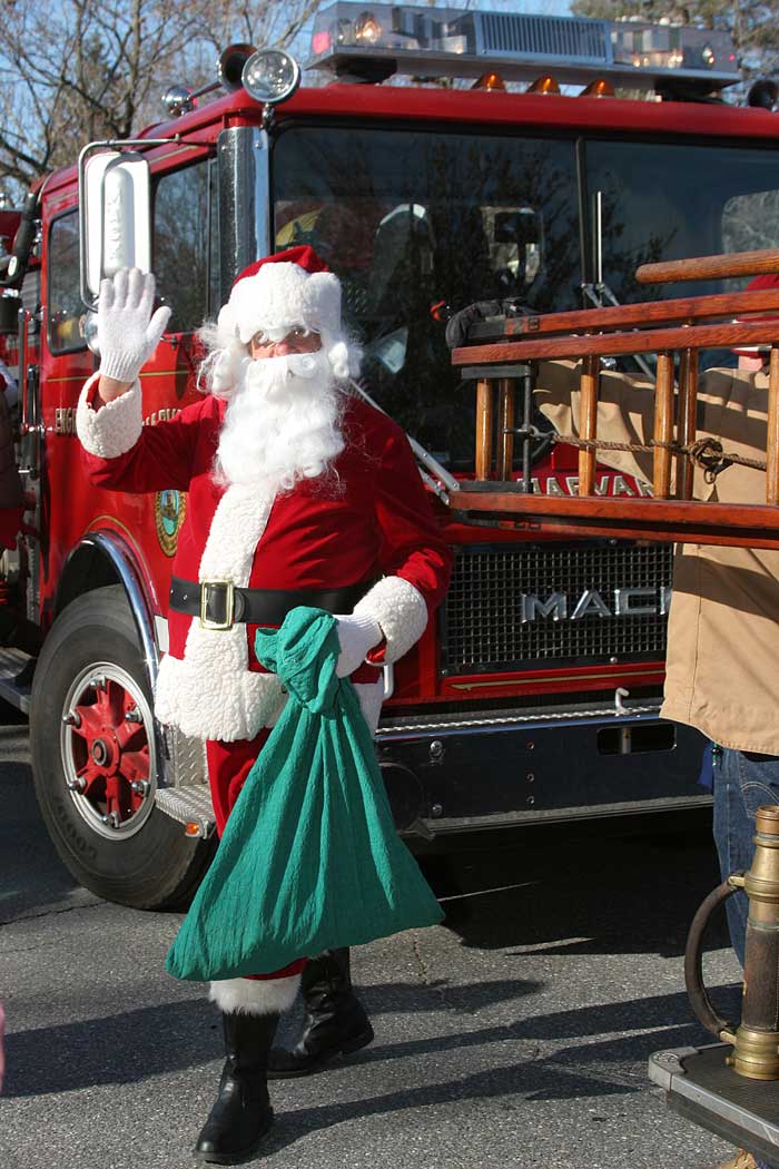 As town tradition dictates, Santa arrives at a lunch in his honor on a town firetruck.