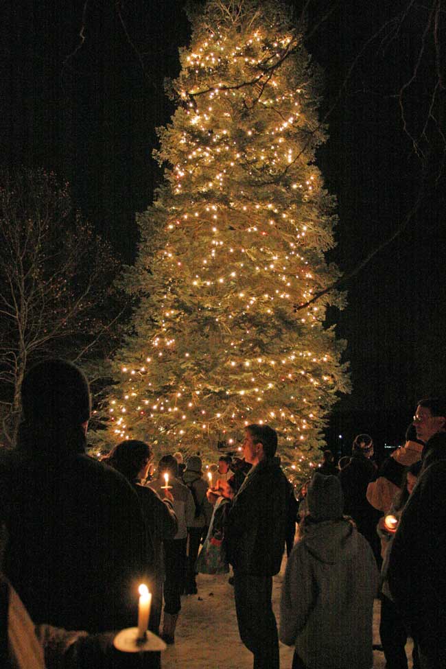 Residents gather 'round the just-lit tree on the Common.