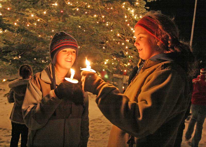 Christie Devlin and Kate Lee light their candles.