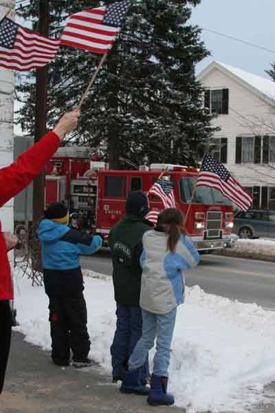 Adults and children alike wave flags of appreciation for Corporal McClure as he was escorted into town.