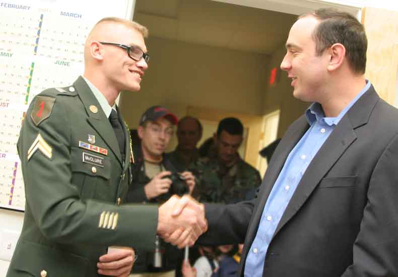 Corporal McClure shakes hands with State Representative Jamie Eldridge.