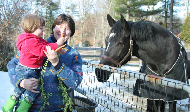 Cynthia Riddle and daughter Julia feed carrots to their horse Nora. (Photo by Lisa Aciukewicz) Cynthia Riddle and daughter Julia feed carrots to their horse Nora. (Photo by Lisa Aciukewicz)