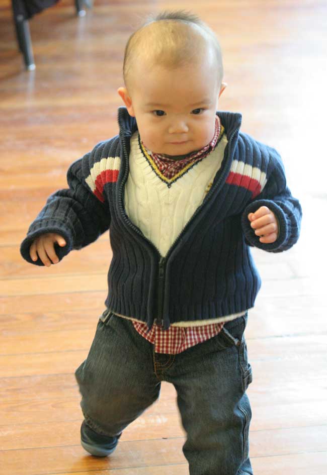 Eighteen-month-old Isaac Xu explores Volunteers Hall during Hugh Hanley’s Circle of Songs.