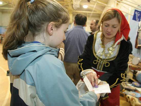 Sophia Collins gets her passport stamped by Koralia Franklin, representing Greece.