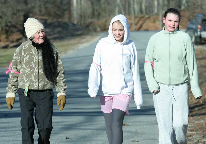Ruthie Broughton, Trish Kelley, and Olivia Maclean talk as they walk down Madigan Lane in the Good Friday walk. This year marked Broughton’s 31st year of participation.