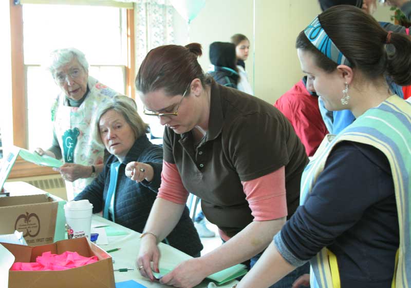Peggy Braat, Sydney Blackwell, Rita Fagan, and Christine House sign in walkers and collect donations.