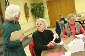 Lynda King, left, answers a question from Jean McCrosky as Dorothy Solbrig reads a handout at King’s talk on genealogy for the Woman’s Club. (Photo by Lisa Aciukewicz)