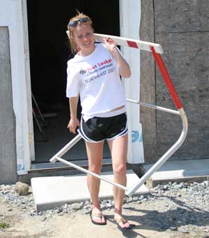 Bromfield senior Liz Lee carries a hurdle out of the basement storage area of the field house she is building with the help of the community. (Photo by Lisa Aciukewicz)