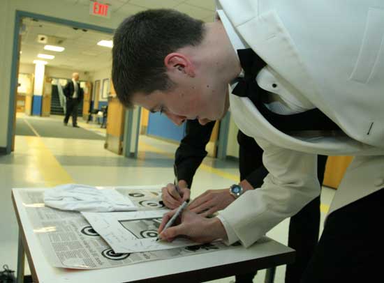 Matthew Chambers signs thank you gifts for Chef Paul Correnty and art teacher Sharon Chandler, who came up with the idea of the dinner dance.