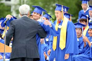 English teacher Chris Jones gives Will Schwarz a congratulatory hug as he and Jeff Lee accept their Harvard Teachers Associaton awards.
