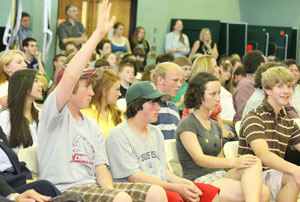 Students raise their hands with questions for the governor.