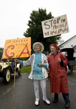 Irene Mannix and Janet Fowke have their signs ready for The Council on Aging float. (Photo by Ellen Harasimowicz)