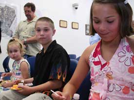 Martineau’s great-grandchildren (left to right) Gracie Martineau, Sammy Albert, and Angela Albert celebrate their great-grandfather’s accomplishments with cake and ice cream after the ceremony.