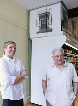 Lyn Horowitz (left) and David Reed, owner of the General Store in the 1950s when it was known as Kerley, Reed, and Bryant, stand in front of a photo of the old store.