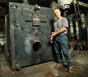 Mark Force, director of maintenance for the schools, shows off the boiler at Bromfield that will be replaced this fall. (Photo by Lisa Aciukewicz)