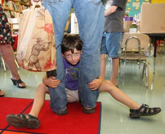 Isaac Noble seeks shelter in his dad’s legs at the elementary school open house.