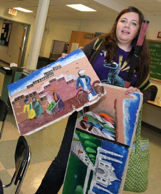 Bromfield junior Halsey Berryman shows off ceiling tiles she painted for geography teacher Bryce Mattie.