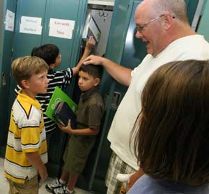 Third-grader Dmitri Dutkewych listens to teacher Rob Cullinane as he asks for his help in acclimating new student Michael Placido (center) to the elementary school. (Photo by Lisa Aciukewicz)