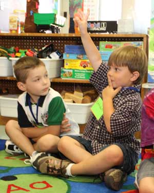 Zachary Pelak watches as Ethan Taylor raises his hand during attendance on the first day of kindergarten at HES.