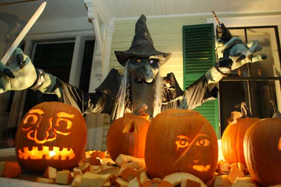A power-tool-wielding witch hovers over pumpkins at the Pumpkin Plant on the porch of 13 Mass. Ave.