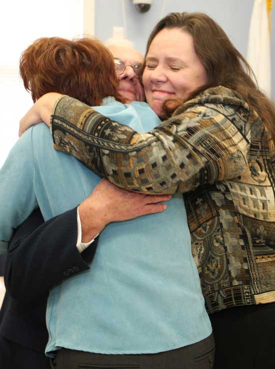 Janice (left) and Jeannie (right) Bourgeois hug their father Amedee (center). Jeannie was instrumental in getting her father’s service recognized.